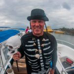 A diver dressed as a canibal with a Skeleton shirt and skull necklace on a halloween event dive in roatan.