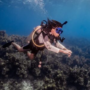 A teen girl scuba dives for the first time as part of Sun Divers scuba certification scholarship program.