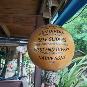 The Golden Buoy featuring the names and dates of all the Roatan dive shops that have won it. 