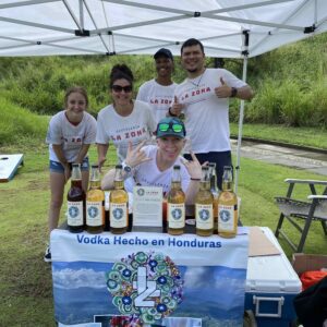 A group of La Zona vodka employees pose at their tasting table on the golf course.