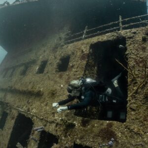 A women diver emerges from a swimthrough in the shipwreck Odyssey in Roatan. 