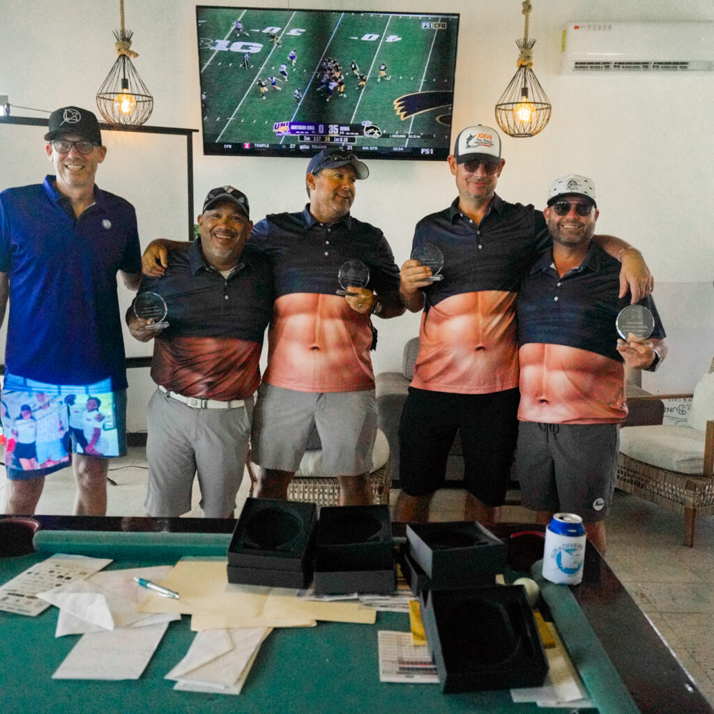 The winnners of the Sun Divers charity golf tournament stand with their tropies.